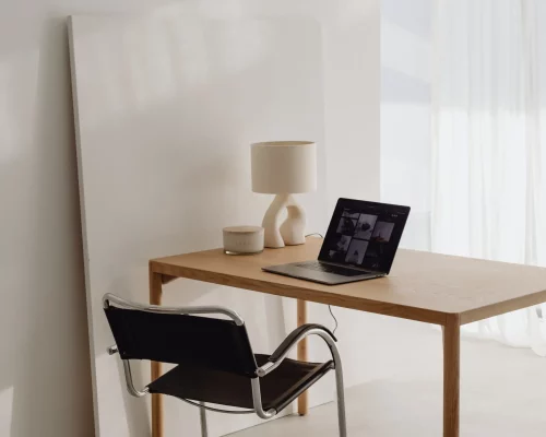 biurko z otwartym laptopem, przygotowane do terapii online z dziećmi, młodzieżą lub dorosłymi